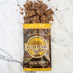 12 oz Killer Pecan Toffee Bag. Flat lay of the Killer Pecan Toffee Bag with Milk Chocolate, Killer Pecan Toffee Spilling out.